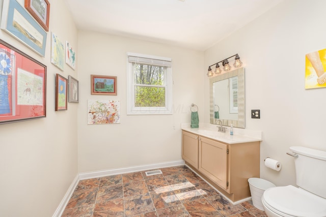 6181 Perry Rd, Centerburg, OH 43011 - bathroom with visible vents, toilet, vanity, stone finish flooring, and baseboards
