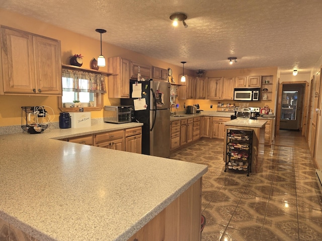kitchen featuring a textured ceiling, a sink, appliances with stainless steel finishes, and beverage cooler