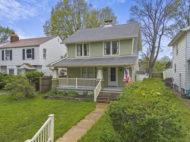 view of front of home featuring a front lawn, fence, a chimney, a shingled roof, and a porch