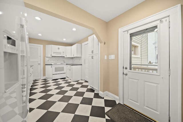 kitchen featuring dark countertops, white appliances, dark floors, white cabinetry, and decorative backsplash