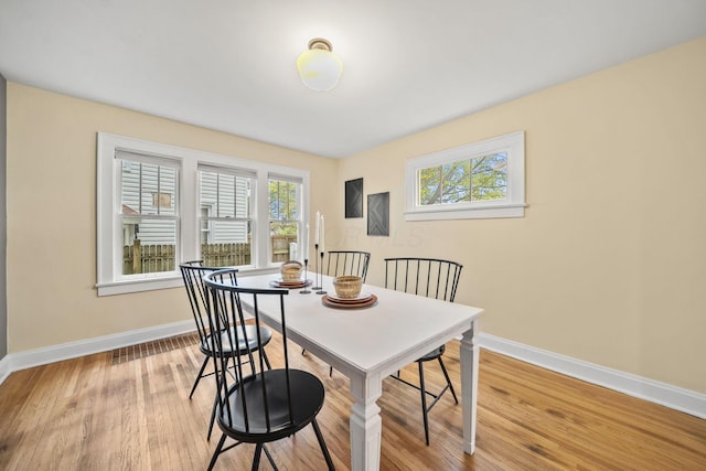 dining space featuring baseboards and light wood-type flooring