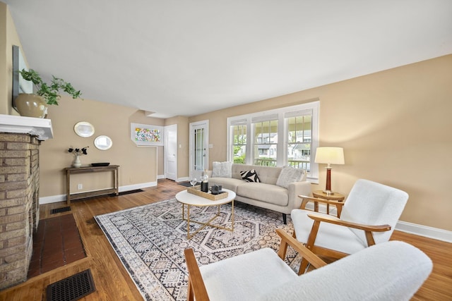 living area featuring baseboards, wood finished floors, and visible vents