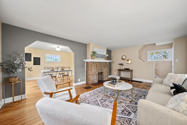 living room featuring baseboards, wood finished floors, and a fireplace