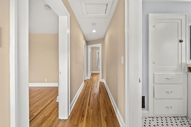 hallway featuring baseboards and wood finished floors