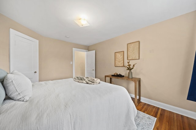 bedroom featuring baseboards and dark wood finished floors