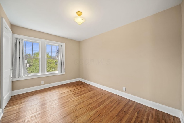empty room featuring baseboards and wood finished floors