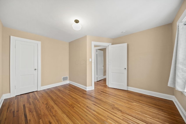 unfurnished room with baseboards, visible vents, and light wood-style floors