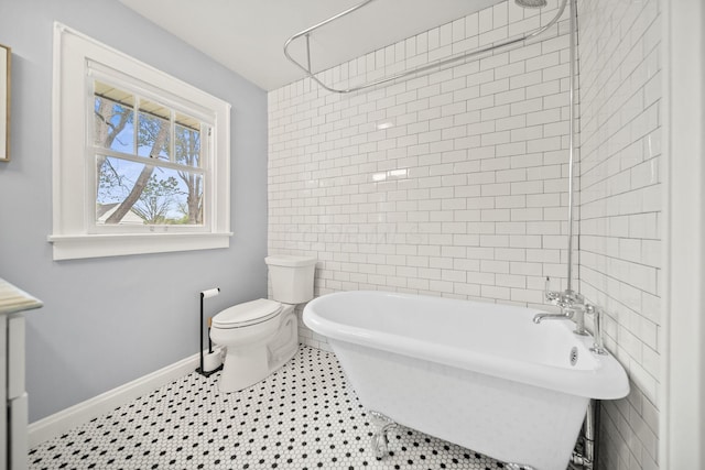 full bath with a freestanding tub, baseboards, walk in shower, and toilet