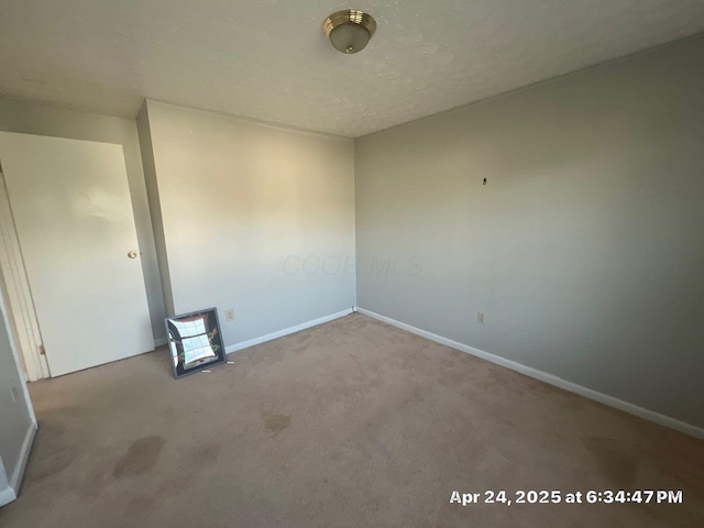 spare room with carpet and baseboards
