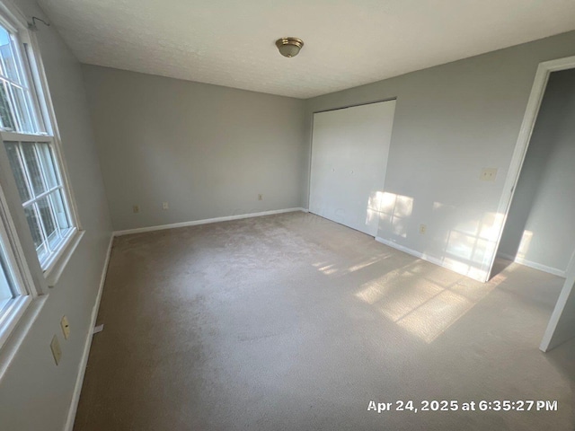 unfurnished bedroom with baseboards, carpet, and a closet