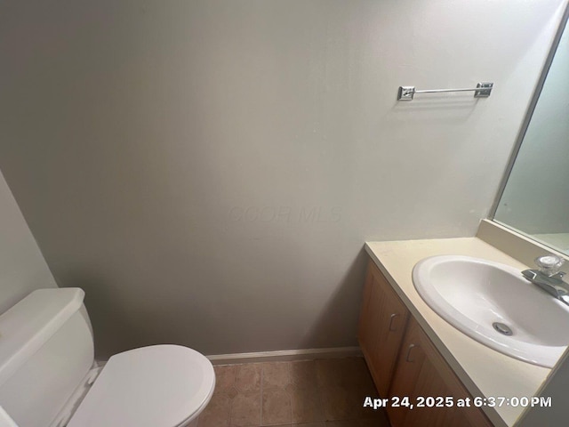 bathroom featuring baseboards, toilet, and vanity