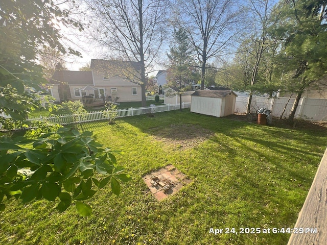 view of yard featuring an outdoor structure, a shed, and a fenced backyard