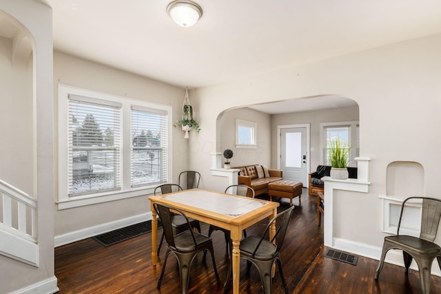 1284-1286 S Champion Ave, Columbus, OH 43206 - dining room featuring baseboards, visible vents, arched walkways, and wood finished floors