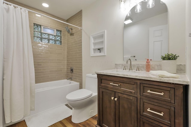 bathroom with vanity, toilet, wood finished floors, and shower / bath combo with shower curtain