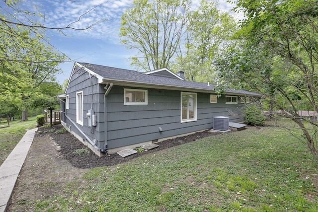view of home's exterior with a chimney, a yard, and cooling unit
