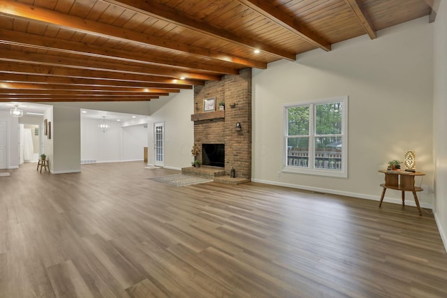 unfurnished living room with baseboards, wood finished floors, and beam ceiling