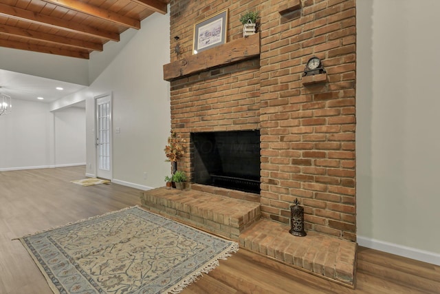 unfurnished living room featuring wood finished floors, wooden ceiling, baseboards, beamed ceiling, and an inviting chandelier
