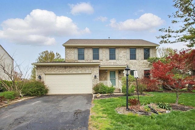 traditional-style home featuring a garage, aphalt driveway, and stone siding