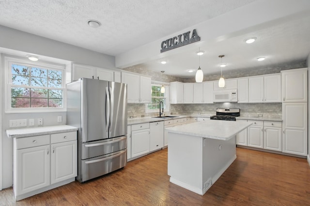 kitchen with tasteful backsplash, white cabinets, appliances with stainless steel finishes, and a sink