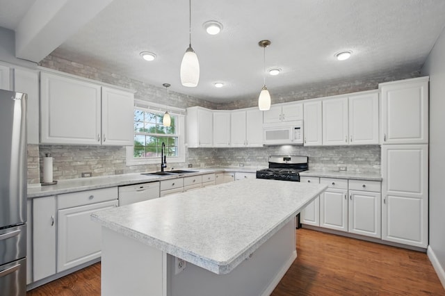 kitchen featuring tasteful backsplash, stainless steel appliances, light countertops, and a sink