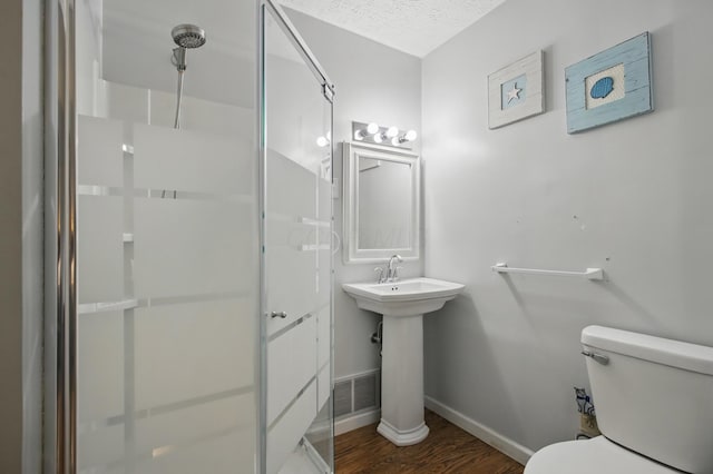 full bath featuring wood finished floors, toilet, a shower stall, and baseboards