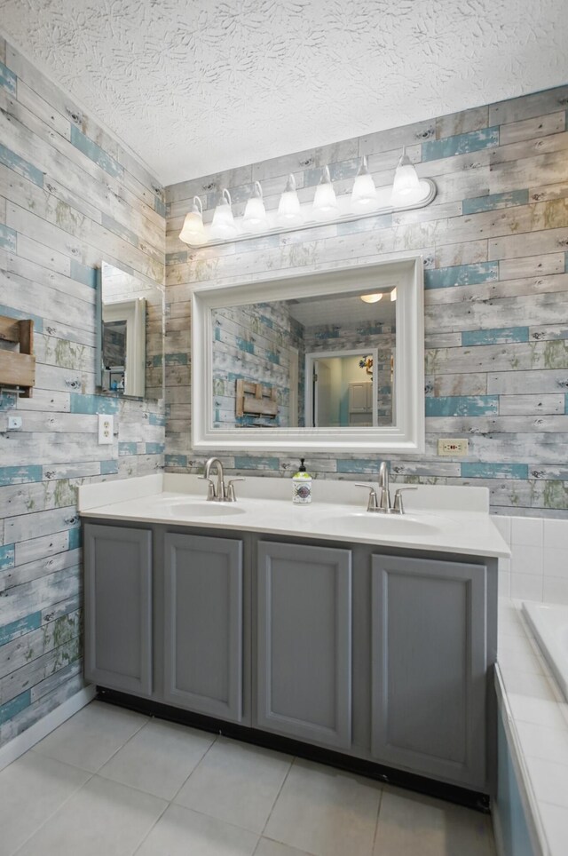 full bathroom with wood walls, tile patterned flooring, and a sink