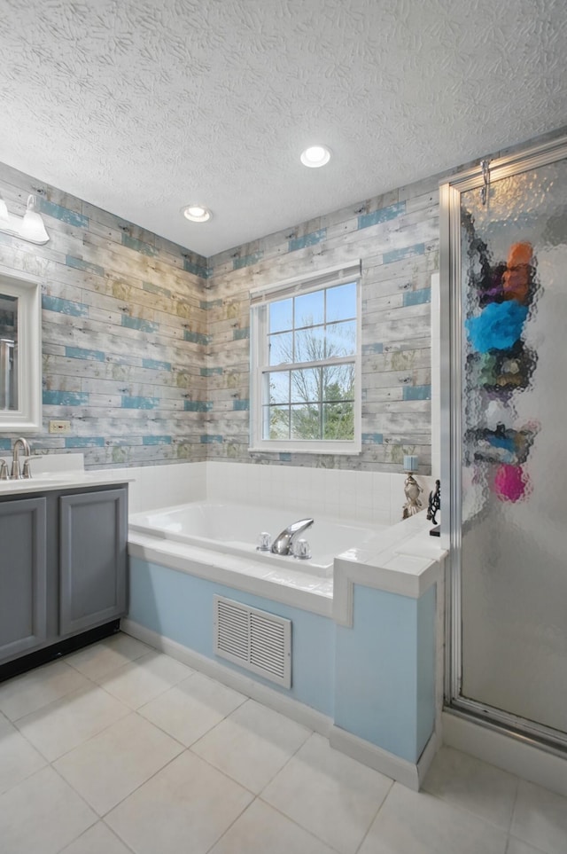full bathroom featuring tile patterned floors, a textured ceiling, visible vents, and a stall shower