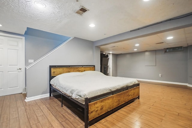 bedroom with visible vents, light wood finished floors, and baseboards