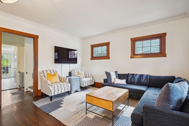 living room featuring plenty of natural light, ornamental molding, wood finished floors, baseboards, and radiator heating unit