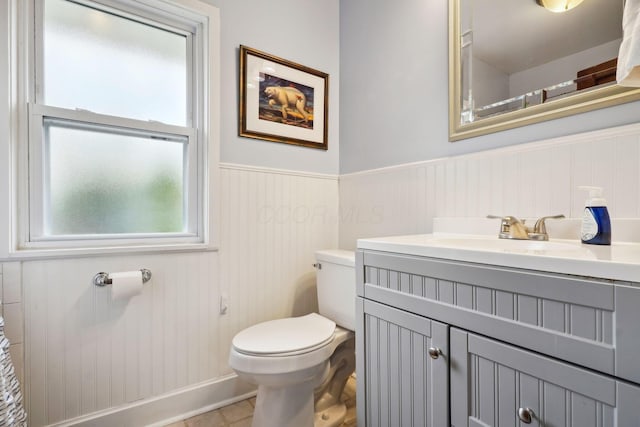 bathroom featuring toilet, wainscoting, vanity, and tile patterned flooring