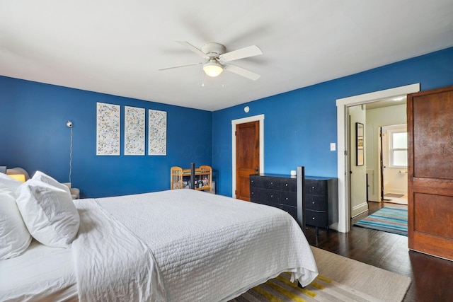 bedroom with dark wood-style floors, a ceiling fan, and baseboards