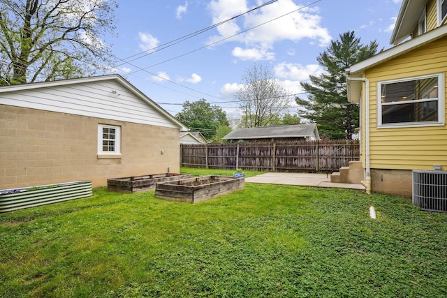 view of yard with a vegetable garden, central air condition unit, and a patio
