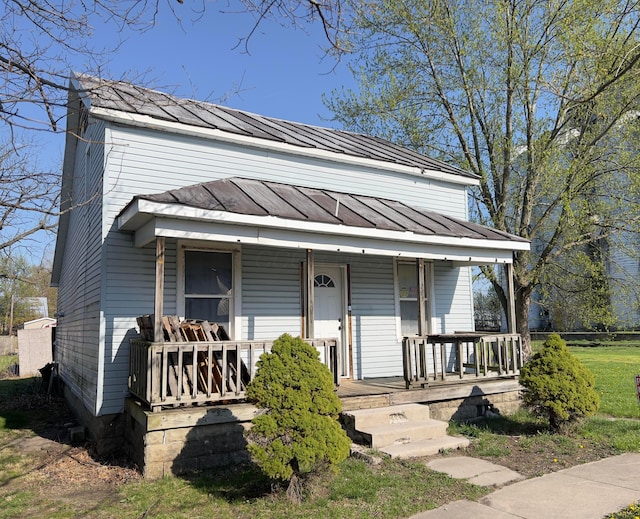 traditional-style house with metal roof, a standing seam roof, and covered porch