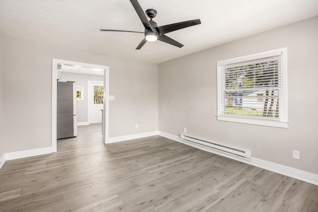 116 W S Ave, Plain City, OH 43064 - unfurnished room featuring baseboards, a ceiling fan, wood finished floors, and a baseboard heating unit