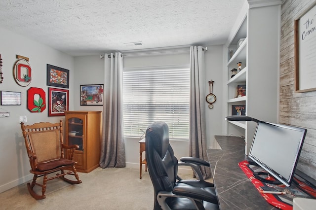 home office with baseboards, carpet flooring, a textured ceiling, and built in shelves