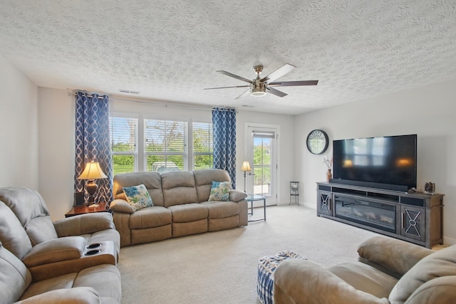 living area with a ceiling fan, carpet flooring, a textured ceiling, and visible vents