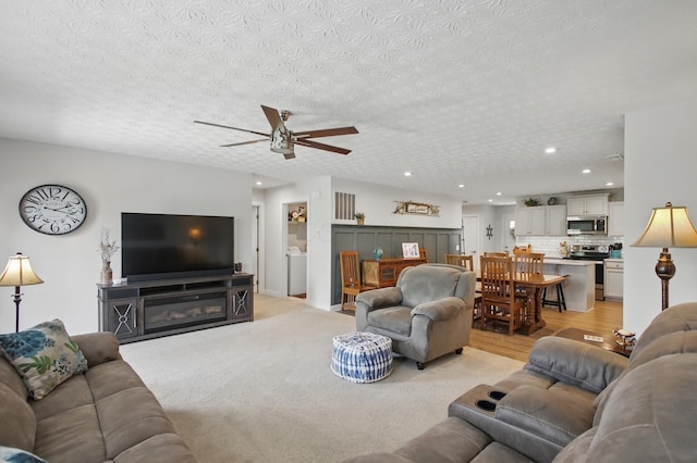 living area featuring a ceiling fan, a textured ceiling, and recessed lighting