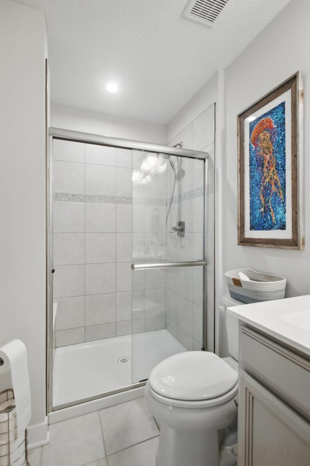 full bath with tile patterned flooring, vanity, toilet, a shower stall, and visible vents