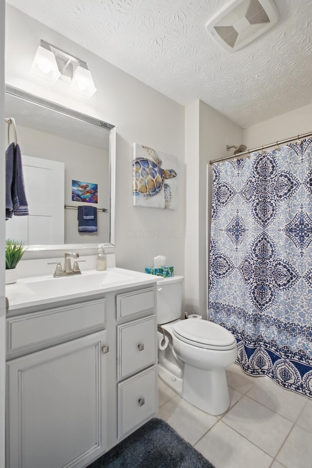 bathroom featuring a textured ceiling, visible vents, tile patterned flooring, vanity, and toilet