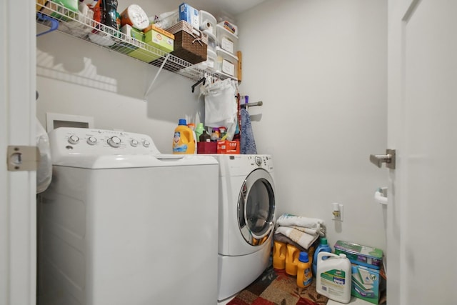 clothes washing area featuring laundry area and washer and clothes dryer
