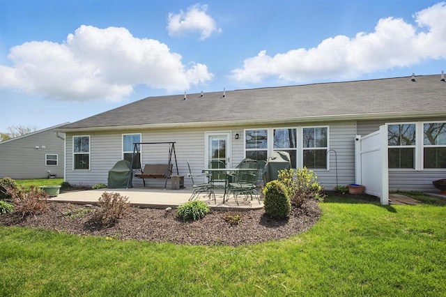 back of property featuring a lawn and a patio area