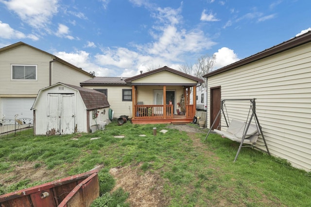 rear view of property with a lawn, a storage unit, fence, and an outdoor structure