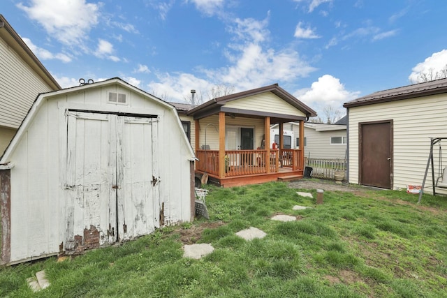 rear view of house featuring a storage unit, a yard, a wooden deck, and an outdoor structure
