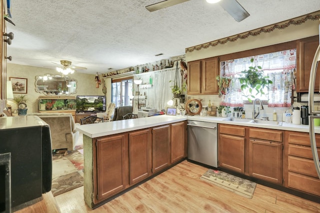 kitchen featuring a sink, ceiling fan, a peninsula, light countertops, and dishwasher