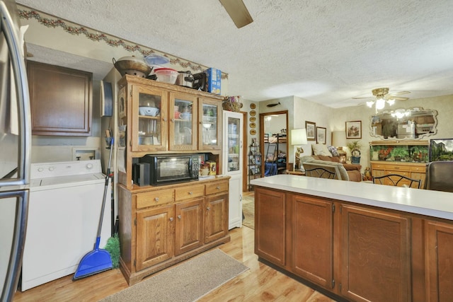 kitchen with black microwave, a textured ceiling, a ceiling fan, and washer / clothes dryer