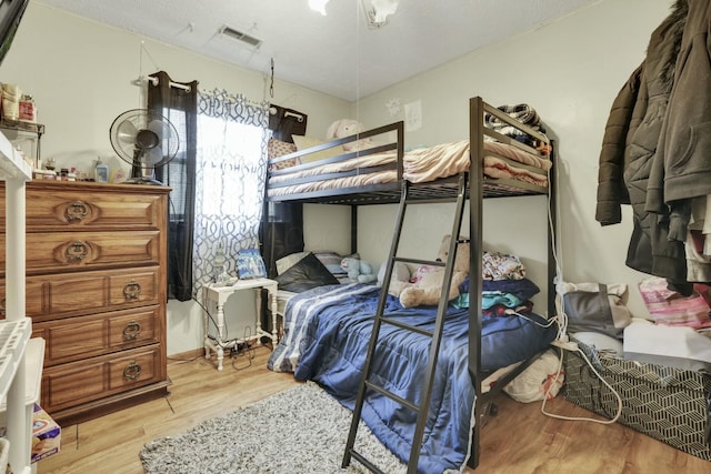 bedroom featuring wood finished floors and visible vents