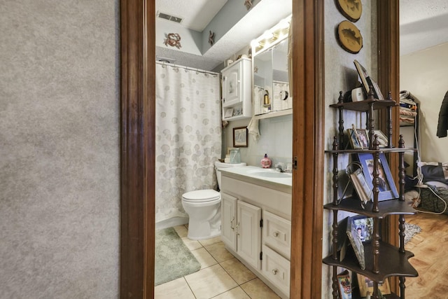 bathroom with a shower with curtain, visible vents, toilet, vanity, and tile patterned flooring