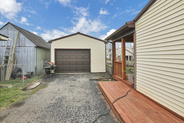 detached garage featuring fence and driveway