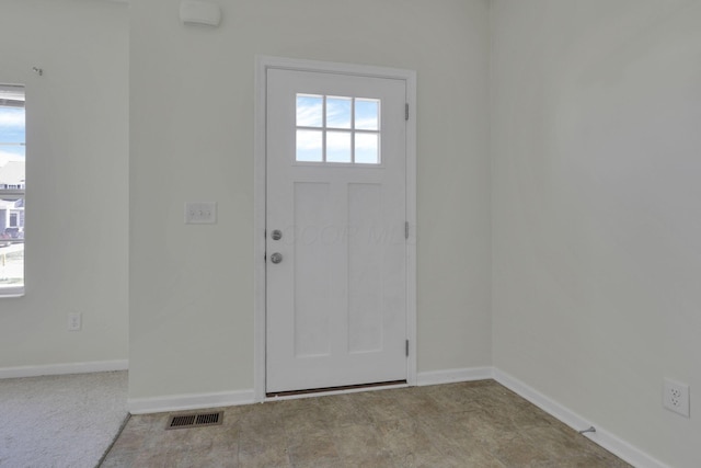 foyer featuring baseboards and visible vents