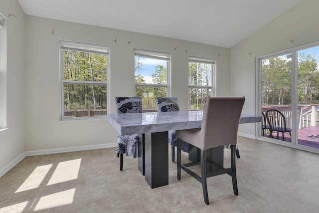 dining room with baseboards and vaulted ceiling
